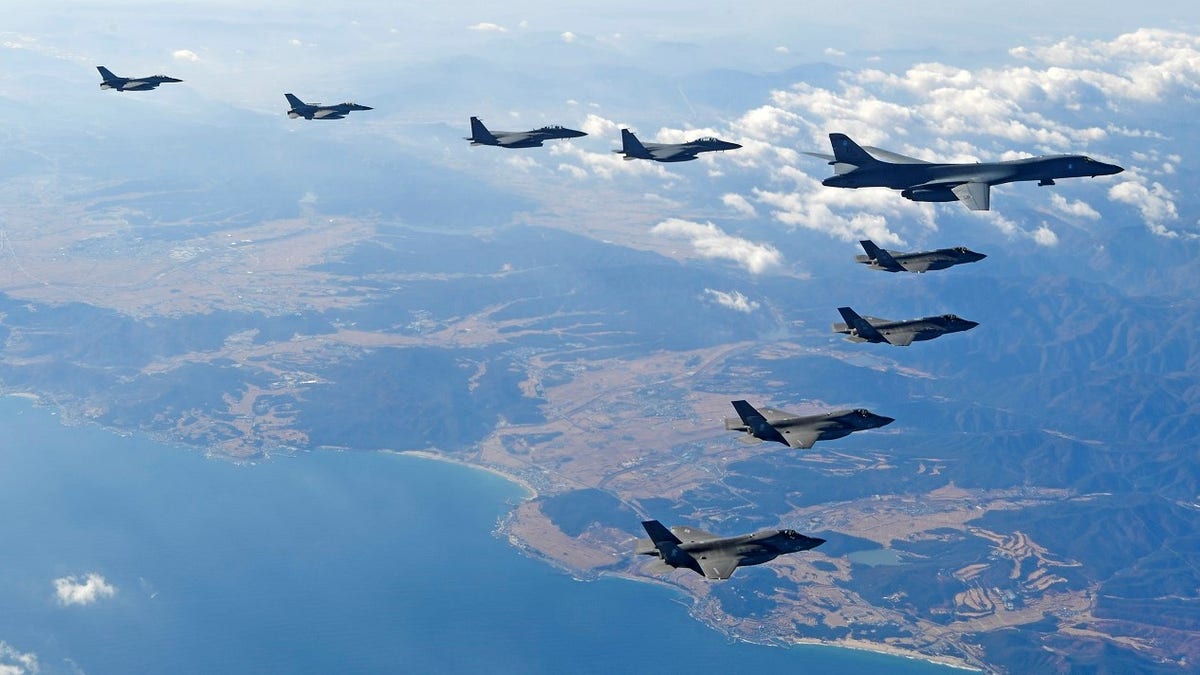 In this photo provided by South Korea Defense Ministry, U.S. Air Force B-1B bomber, right top, flies over the Korean Peninsula with South Korean fighter jets and U.S. fighter jets during the combined aerial exercise, South Korea, Wednesday, Dec. 6, 2017. The United States flew a B-1B supersonic bomber over South Korea on Wednesday in part of a massive combined aerial exercise involving hundreds of warplanes, a clear warning after North Korea last week tested its biggest and most powerful missile yet. (South Korea Defense Ministry via AP)