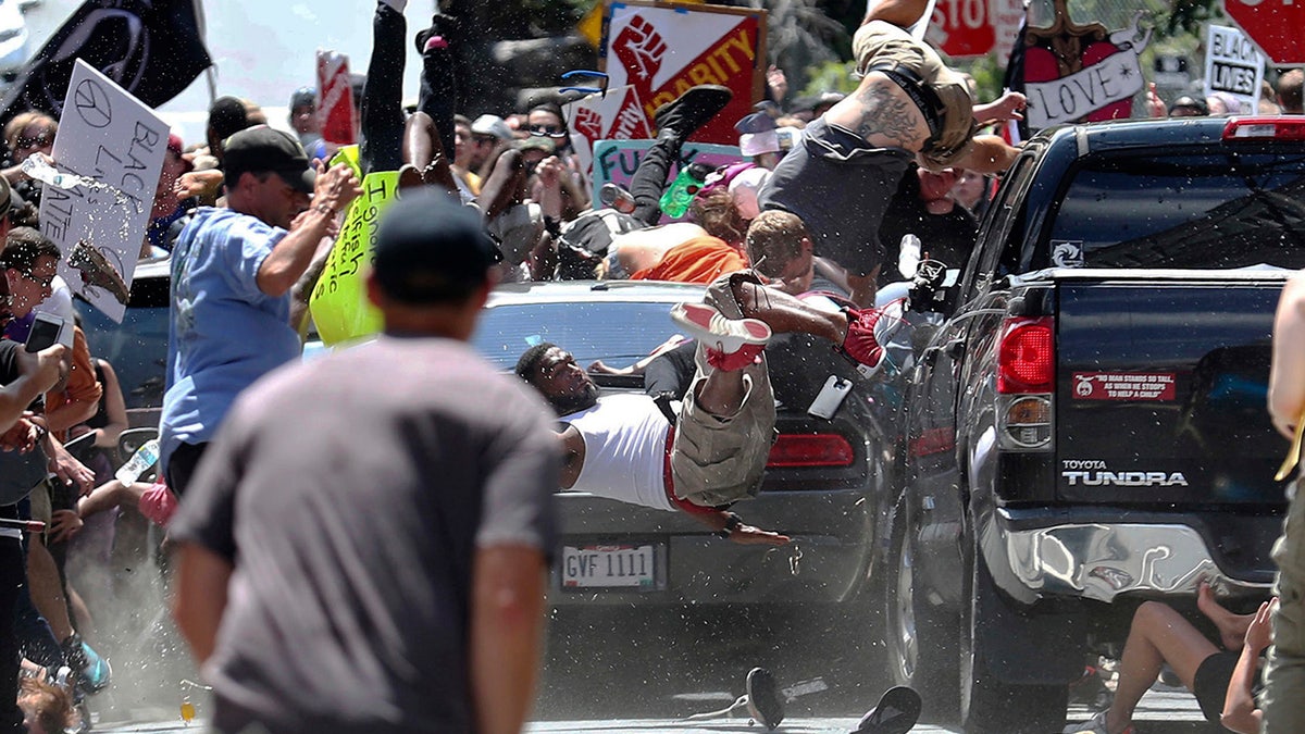 FILE - In this Aug. 12, 2017 file photo, people fly into the air as a vehicle is driven into a group of protesters demonstrating against a white nationalist rally in Charlottesville, Va. James Alex Fields Jr., the man accused of driving into the crowd demonstrating against a white nationalist protest, killing one person and injuring many more, has a preliminary court hearing Thursday, Dec. 14, 2017. (Ryan M. Kelly/The Daily Progress via AP, File)