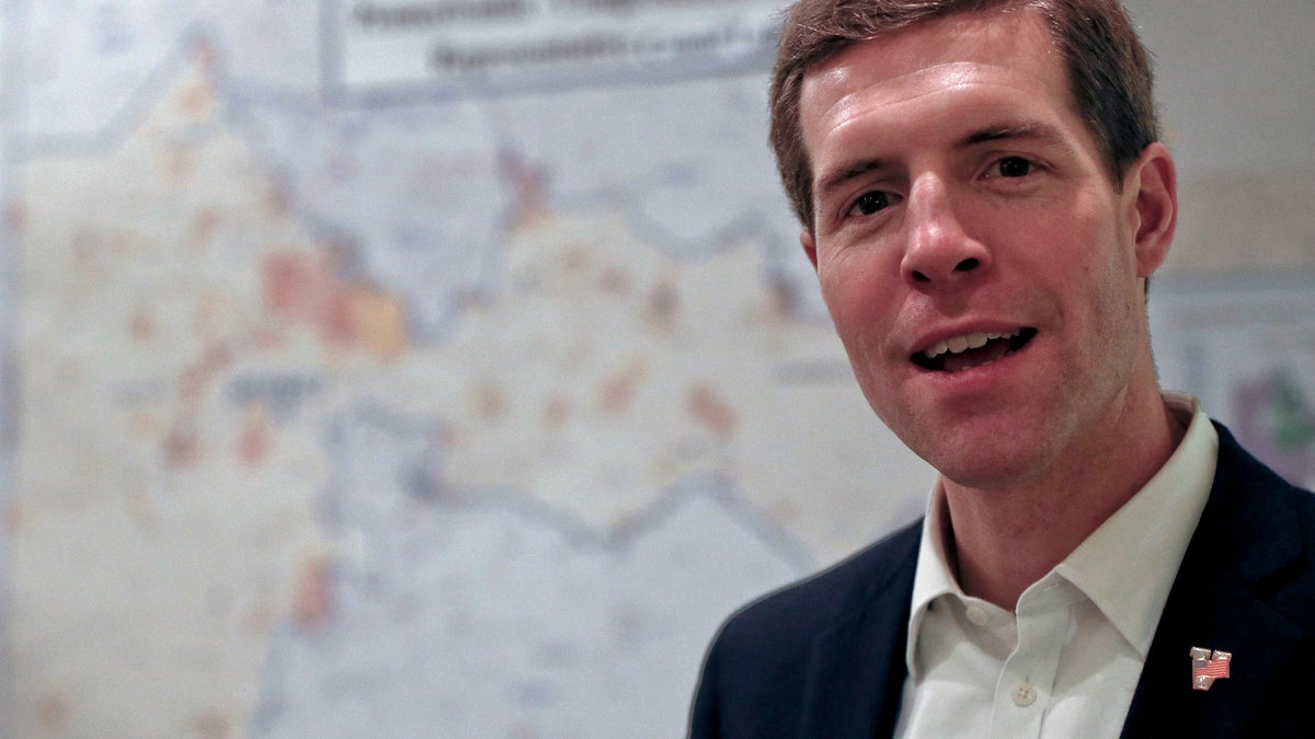 Democrat Conor Lamb, stands in front of the map of the congressional district he is running to represent while at a campaign office, Wednesday, March 7, 2018 in Carnegie, Pa. Lamb is running against Republican Rick Saccone in a special election being held on March 13 for the PA 18th Congressional District vacated by Republican Tim Murphy. (AP Photo/Keith Srakocic)