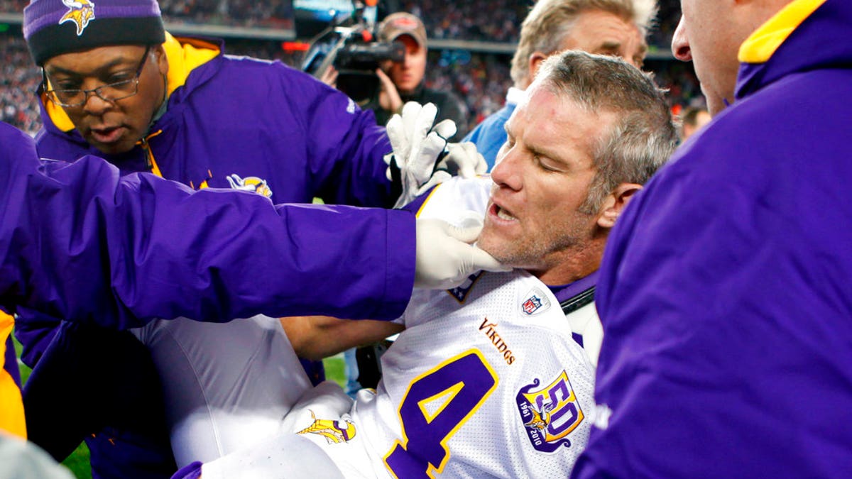 FILE - In this Oct. 31, 2010, file photo, Minnesota Vikings quarterback Brett Favre, center, is helped onto a cart to be taken off the field after a hit from New England Patriots' Myron Pryor during the fourth quarter of an NFL football game in Foxborough, Mass. Favre says he might have had 