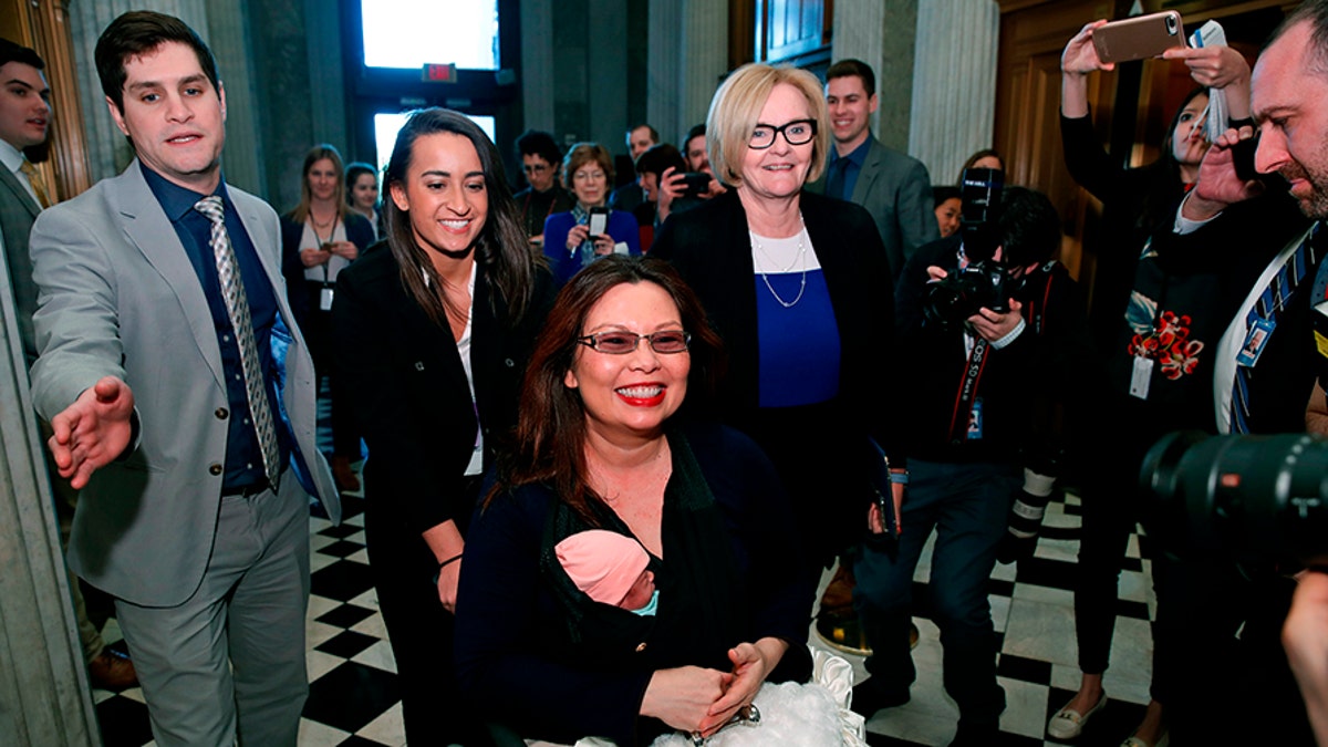 Sen. Tammy Duckworth, D-Ill., carries her baby Maile Pearl Bowlsbey as she heads to the Senate floor to vote, with Sen. Claire McCaskill, D-Mo., at right, on Capitol Hill, Thursday, April 19, 2018 in Washington. (AP Photo/Alex Brandon)