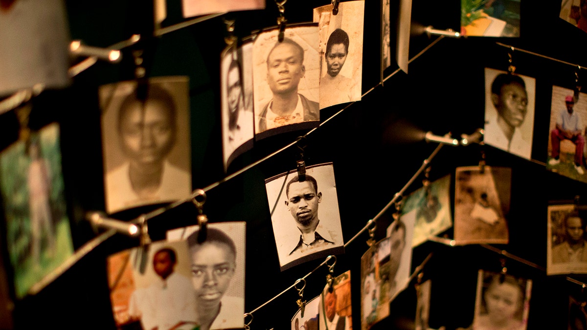 FILE - In this Saturday, April 5, 2014 file photo, family photographs of some of those who died hang in a display in the Kigali Genocide Memorial Centre in Kigali, Rwanda. Mass graves in Rwanda that authorities say could contain more than 2,000 bodies have been discovered in April 2018, nearly a quarter-century after the country's genocide. (AP Photo/Ben Curtis, File)