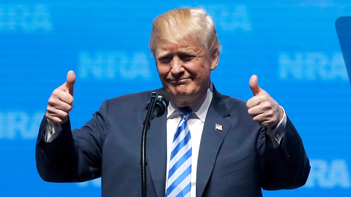 President Donald Trump gestures from the podium as as speaks at the National Rifle Association-Institute 