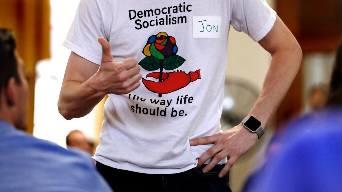 Jon Torsch, center, wears a t-shirt promoting democratic socialism during a gathering of the Southern Maine Democratic Socialists of America at City Hall in Portland, Maine, Monday, July 16, 2018. On the ground in dozens of states, there is new evidence that democratic socialism is taking hold as a significant force in Democratic politics. (AP Photo/Charles Krupa)