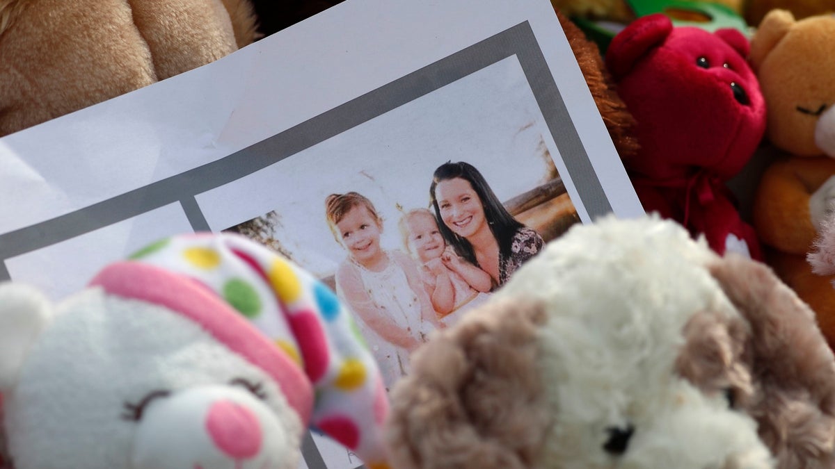 A photograph sits amid the tributes as they grow outside the home where a pregnant woman, Shanann Watts, and her two daughters, Bella and Celeste, lived Thursday, Aug. 16, 2018, in Frederick, Colo. The woman's husband, Christopher Watts, has been arrested on suspicion of killing his family. (AP Photo/David Zalubowski)