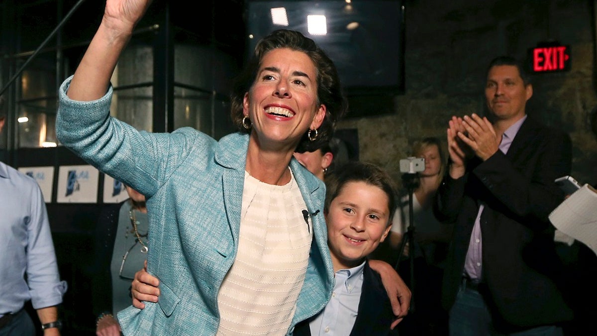 Incumbent Democratic Rhode Island Gov. Gina Raimondo waves to supporters alongside her son, Thompson, at her primary night victory party, Wednesday, Sept. 12, 2018, in Providence, R.I. (AP Photo/Elise Amendola)