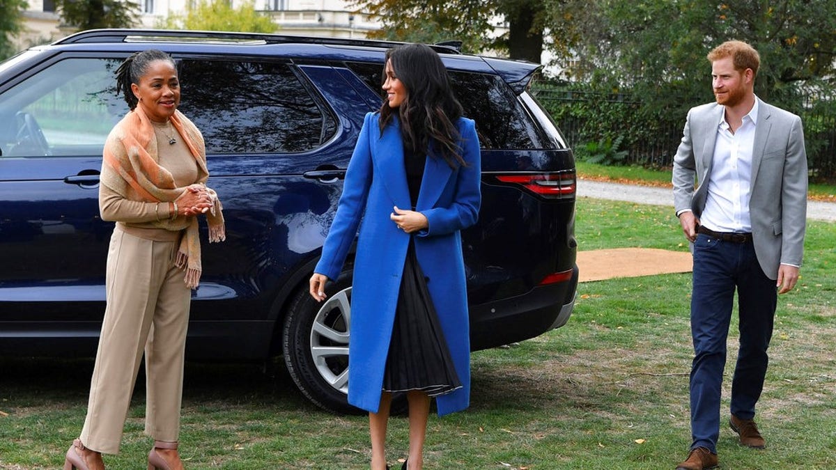 Meghan, the Duchess of Sussex, centre, accompanied by Britain's Prince Harry, the Duke of Sussex and her mother Doria Ragland walk to attend a reception at Kensington Palace, in London, Thursday Sept. 20, 2018.  Markle was joined by her mother for the launch of a cookbook aimed at raising money for victims of the Grenfell fire. Markle, now the Duchess of Sussex, hosted the reception beside her mother, Doria Ragland, to support the cookbook called âTogether.â (Ben Stansall/Pool Photo via AP)