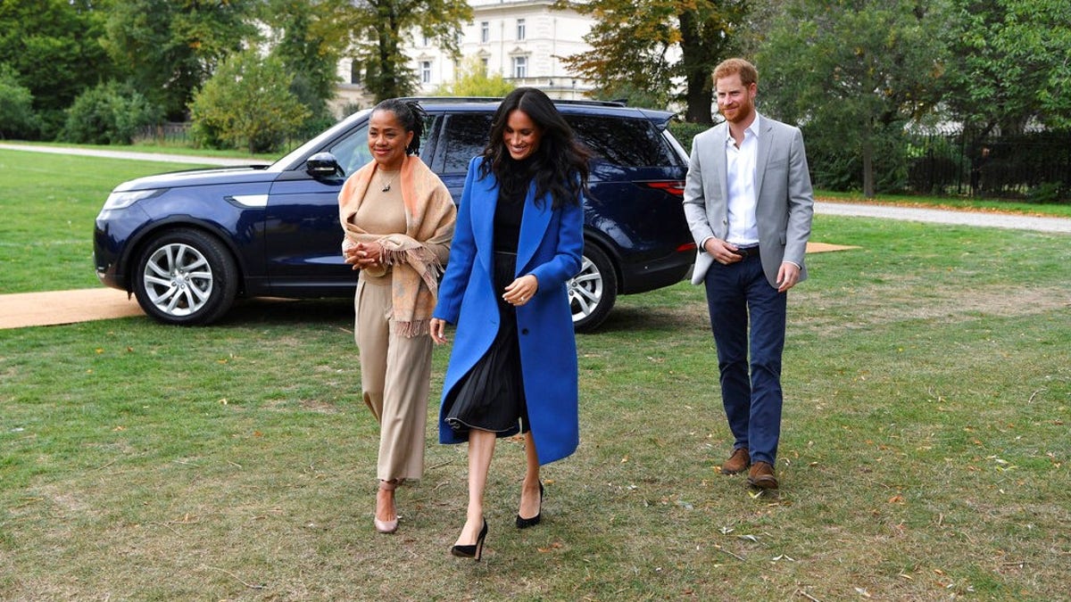 Meghan, the Duchess of Sussex, centre, accompanied by Britain's Prince Harry, the Duke of Sussex and her mother Doria Ragland walk to attend a reception at Kensington Palace, in London, Thursday Sept. 20, 2018.  Markle was joined by her mother for the launch of a cookbook aimed at raising money for victims of the Grenfell fire. Markle, now the Duchess of Sussex, hosted the reception beside her mother, Doria Ragland, to support the cookbook called âTogether.â (Ben Stansall/Pool Photo via AP)