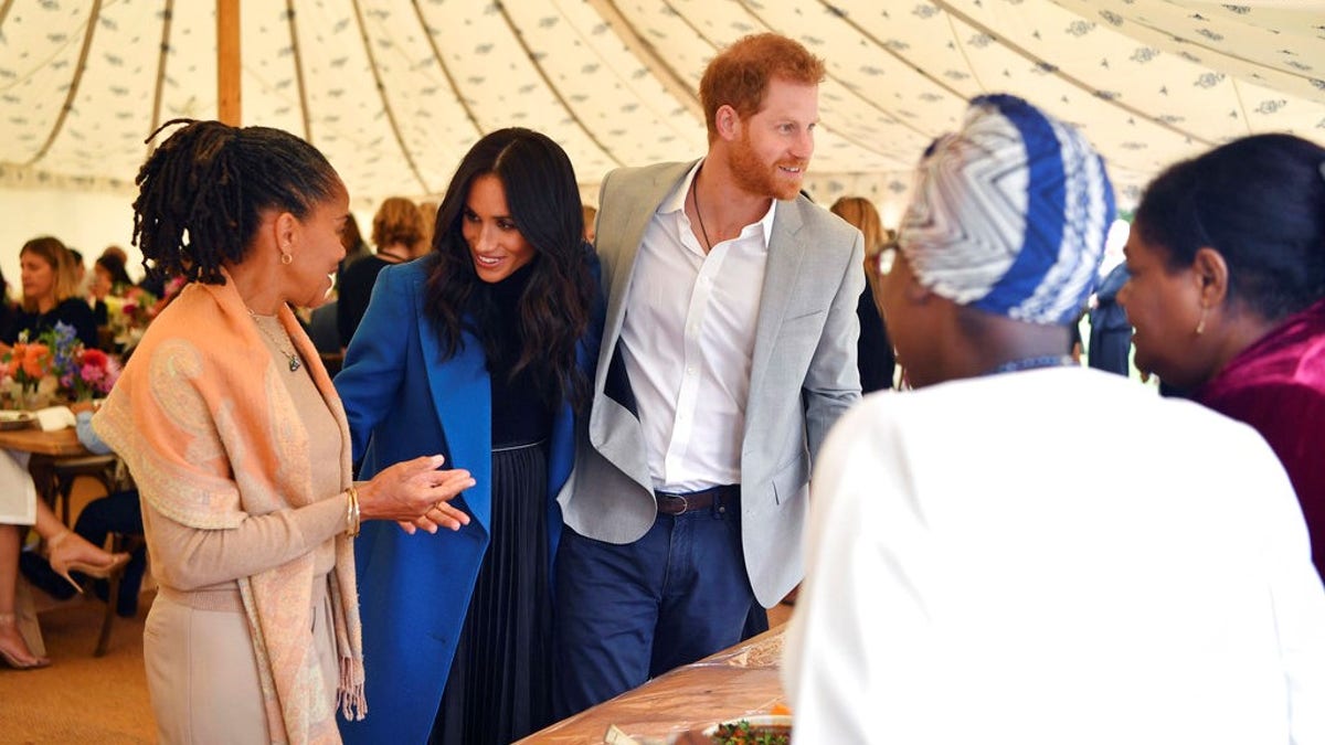 Meghan, the Duchess of Sussex, centre, talks to her mother Doria Ragland, with Prince Harry at centre right, as they attend  a reception for the cookbook 