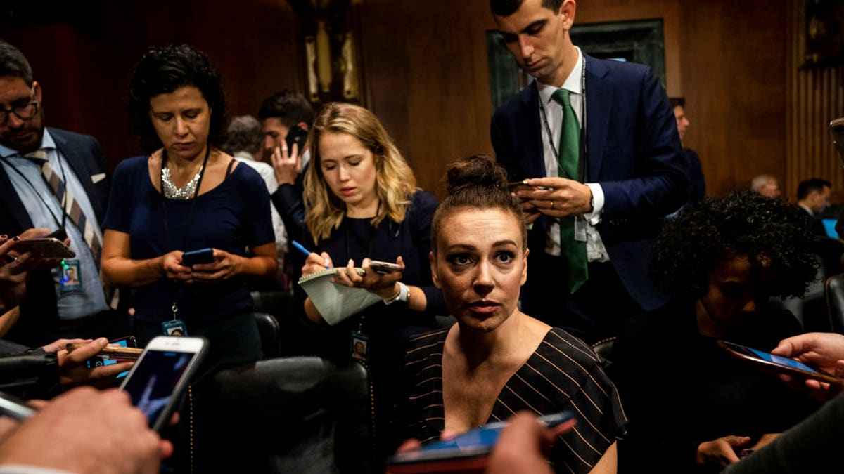 Actress Alyssa Milano is seen before a Senate Judiciary Committee hearing, Thursday, Sept. 27, 2018 on Capitol Hill in Washington with Christine Blasey Ford and Supreme Court nominee Brett Kavanaugh. (Erin Schaff/The New York Times via AP, Pool)