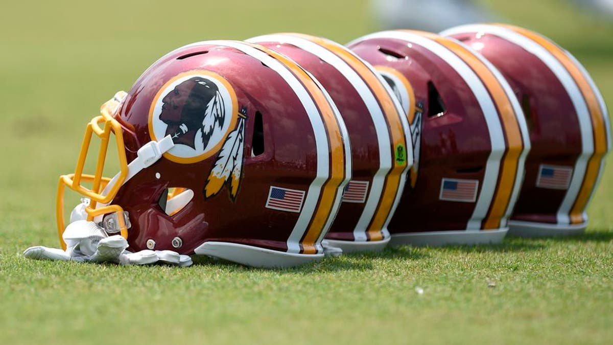 Washington Redskins football helmets sit on the field during an NFL football team practice, Wednesday, June 14, 2017, in Ashburn, Va. (AP Photo/Nick Wass)