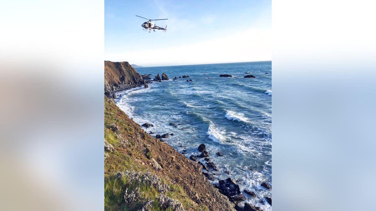 This photo provided by the California Highway Patrol shows a helicopter hovering over steep coastal cliffs Tuesday, March 27, 2018, near Mendocino, Calif., where a vehicle, visible at lower right, plunged about 100 feet off a cliff along Highway 1, killing all five passengers. The California Highway Patrol identified the victims Tuesday as two women from West Linn, Ore., and three children. (California Highway Patrol via AP)