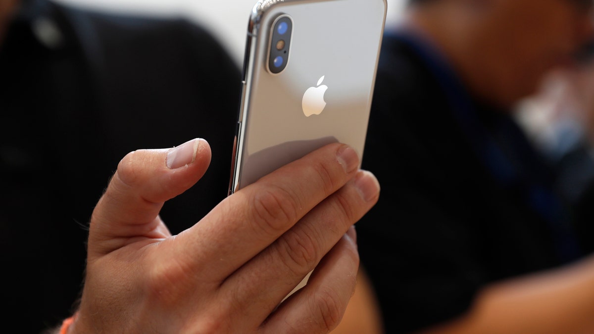 An attendee checks out a new iPhone X during an Apple launch event in Cupertino, California, U.S. September 12, 2017. REUTERS/Stephen Lam - HP1ED9C1L2WEY