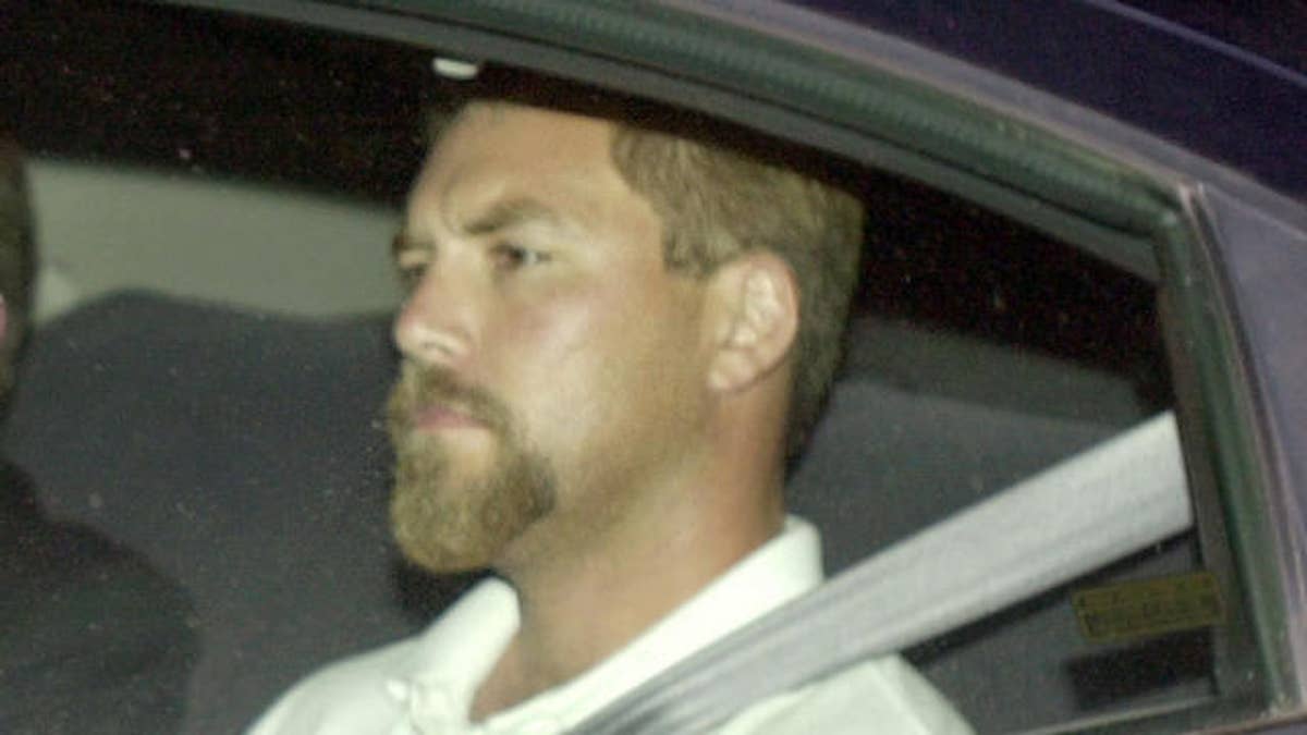 Scott Peterson arriving in back seat of car at the county jail