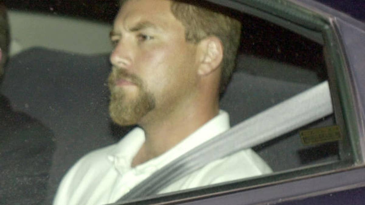 Scott Peterson arriving in back seat of car at the county jail