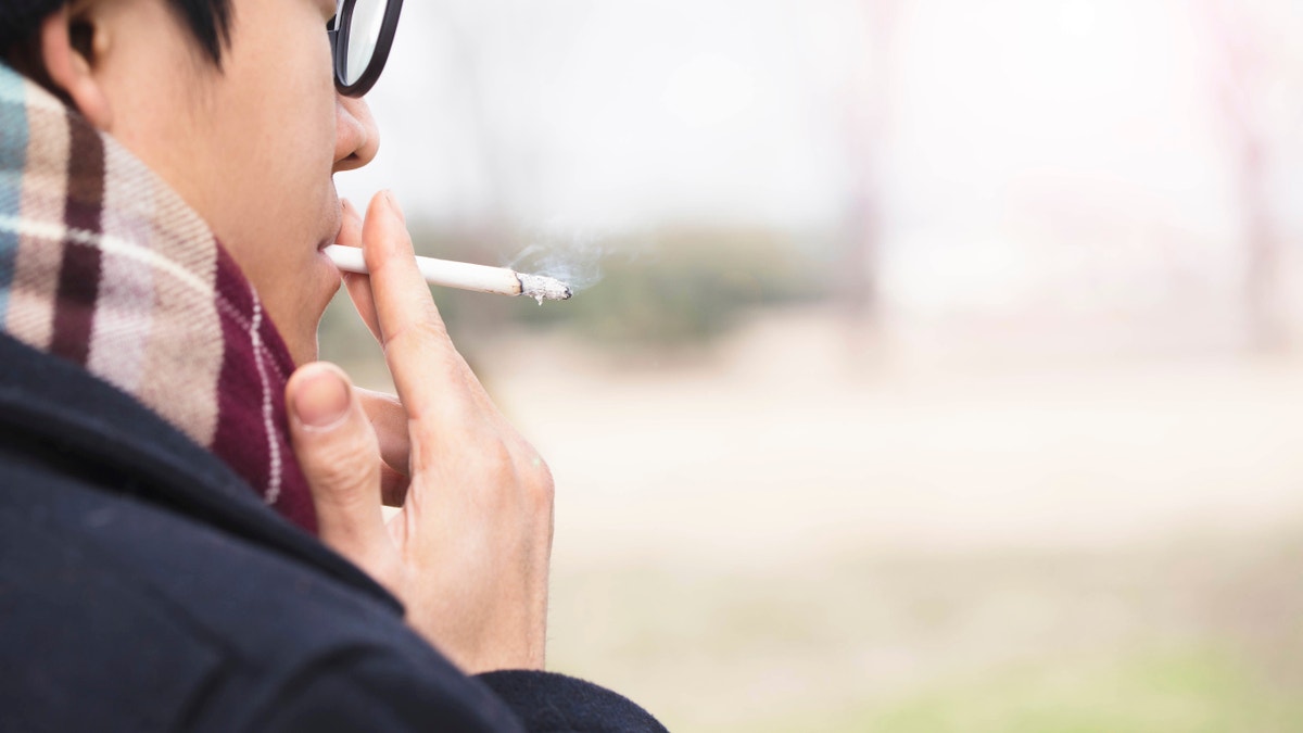 asian man smoking istock