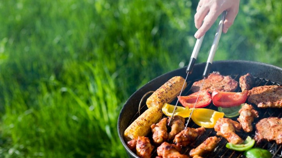 Grilling at summer weekend. Fresh meat and vegetables preparing on grill.