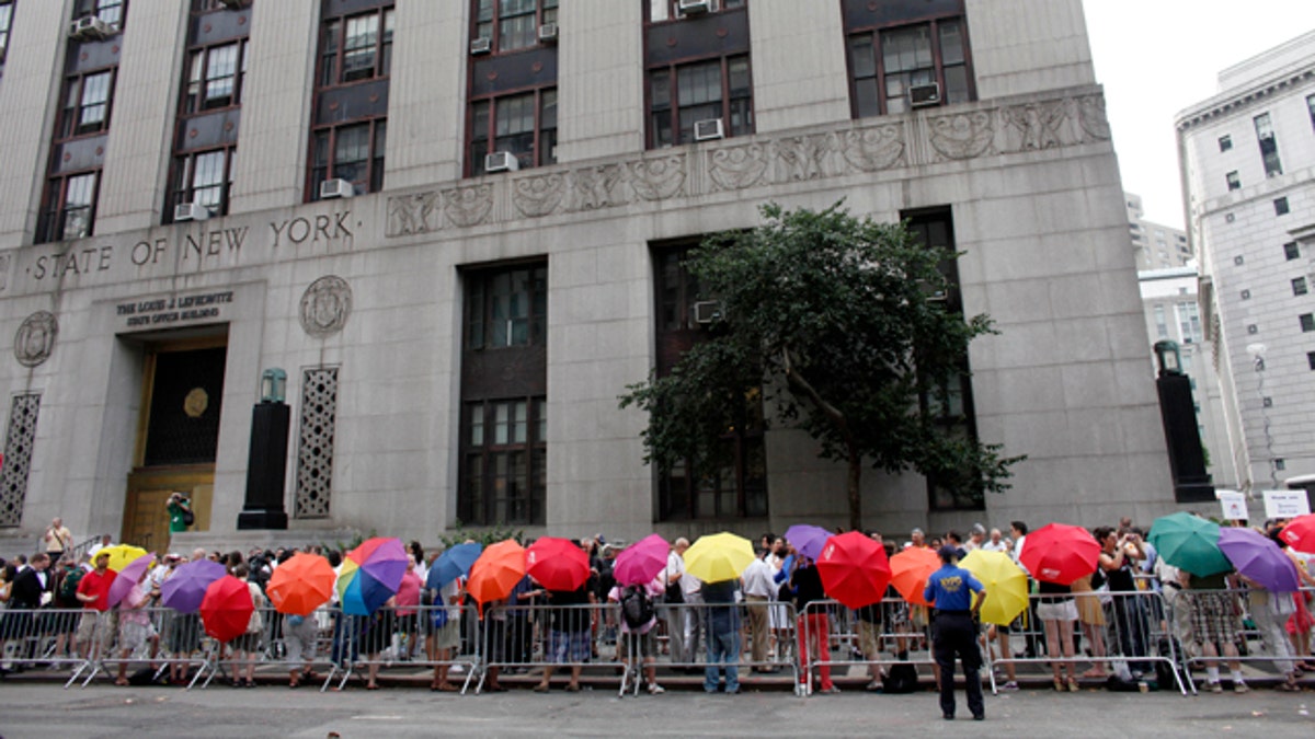 Same-sex couples stand in line to receive wedding licenses. 