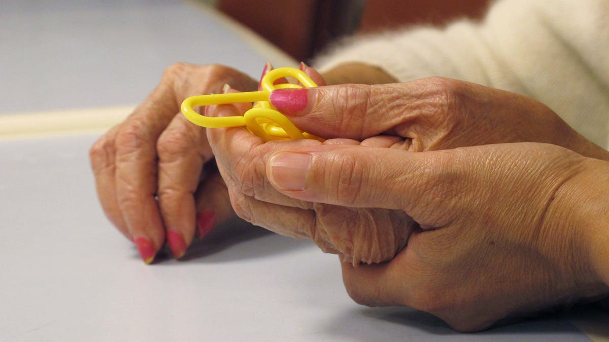 In this Sept. 20, 2012 photo, a physical therapist guides a dementia patient through a puzzle at the Hebrew Home at Riverdale in the Bronx borough of New York. The Hebrew Home has a program that provides care and activity overnight for dementia victims with sleep problems. (AP Photo/Jim Fitzgerald)