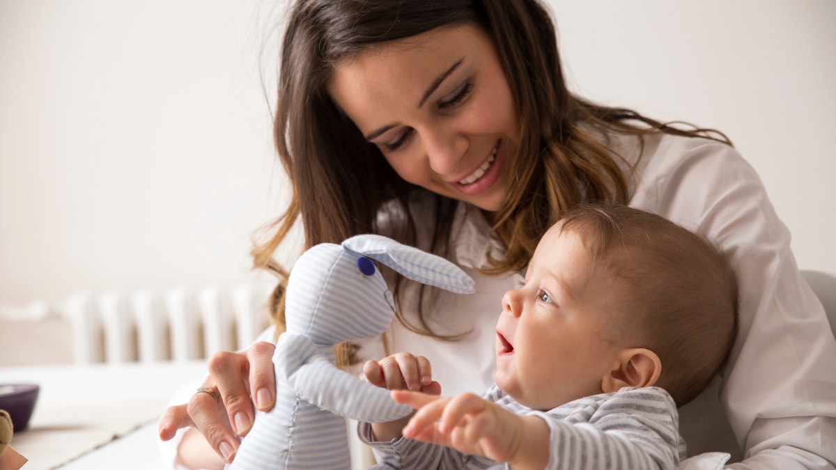 Mother and her baby playing with Bunny toy.