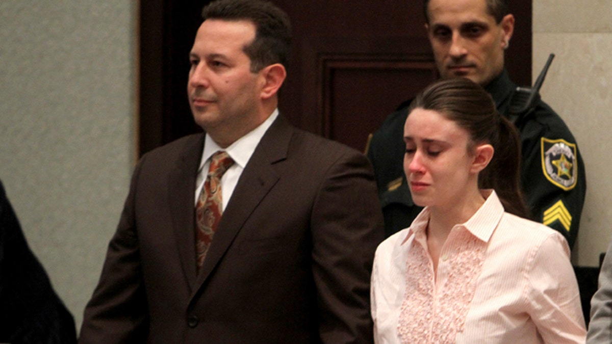 Casey Anthony holds hands with her defense attorneys, Jose Baez, left, and Dorothy Clay Sims, as they listen to the verdict at the Orange County Courthouse in Orlando, Fla., Tuesday, July 5, 2011. The jury acquitted Anthony of murdering her daughter, Caylee. (AP Photo/Red Huber, Pool)