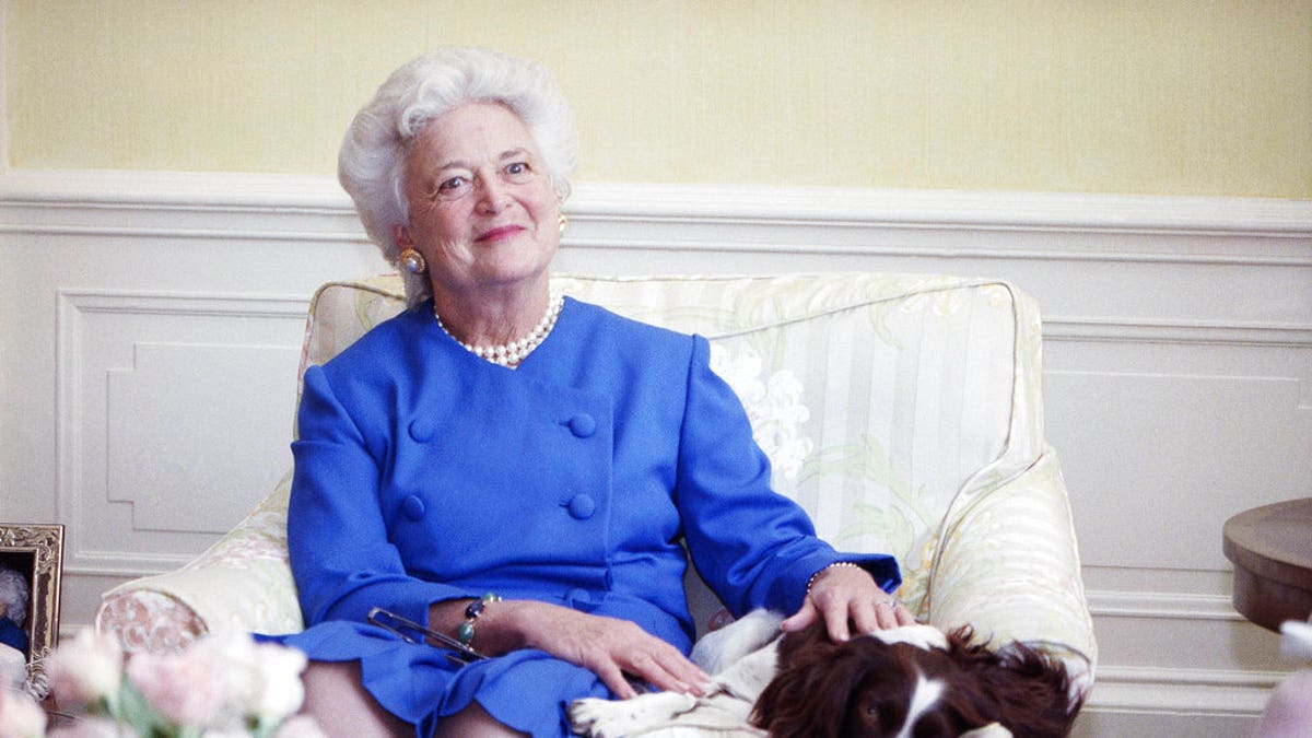 FILE - In this 1990 file photo, first lady Barbara Bush poses with her dog Millie in Washington. A family spokesman said Tuesday, April 17, 2018, that former first lady Barbara Bush has died at the age of 92. (AP Photo/Doug Mills, File)