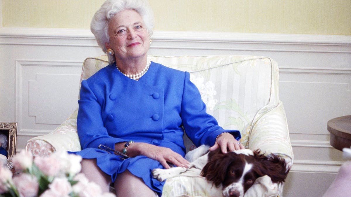 FILE - In this 1990 file photo, first lady Barbara Bush poses with her dog Millie in Washington. A family spokesman said Tuesday, April 17, 2018, that former first lady Barbara Bush has died at the age of 92. (AP Photo/Doug Mills, File)