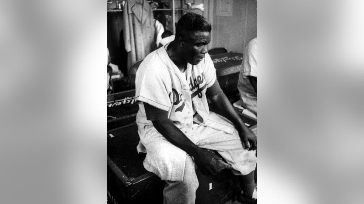 Baseball Player Jackie Robinson looking exhausted and dejected in the locker room with an empty bottle of pop in his hand.  (Photo by Francis Miller//Time Life Pictures/Getty Images)