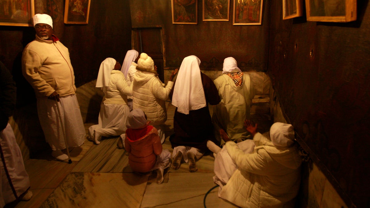 Christian pilgrim worshippers from Nigeria pray in the Grotto of the Church of Nativity, traditionally believed by Christians to be the birthplace of Jesus Christ, in the West Bank town of Bethlehem on Christmas Eve, Tuesday, Dec. 24, 2013. (AP Photo/Majdi Mohammed)