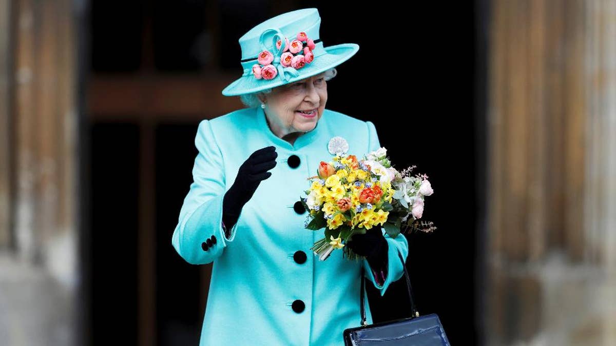 Britain's Queen Elizabeth waves to onlookers as she leaves the Easter Sunday service at St George's Chapel at Windsor Castle in Berkshire, England, Sunday, April 16, 2017. (Peter Nicholls/Pool Photo via AP)