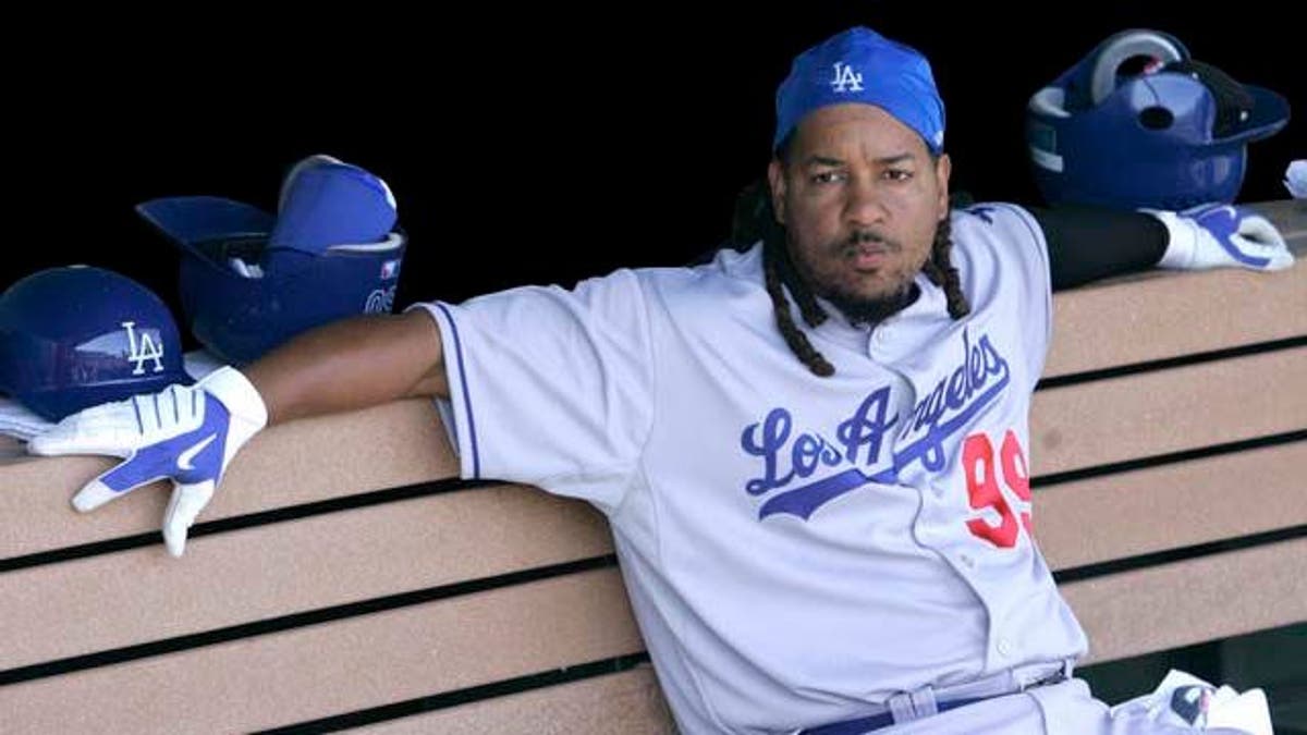 FILE - In this March 23, 2009 file photo, Los Angeles Dodgers' Manny Ramirez sits in the dugout against the Los Angeles Angels in a spring training baseball game in Tempe, Ariz. Ramirez has been suspended for 50 games by Major League Baseball, becoming by far the highest-profile player ensnared in the sport's drug scandals. (AP Photo/Jeff Chiu, File)