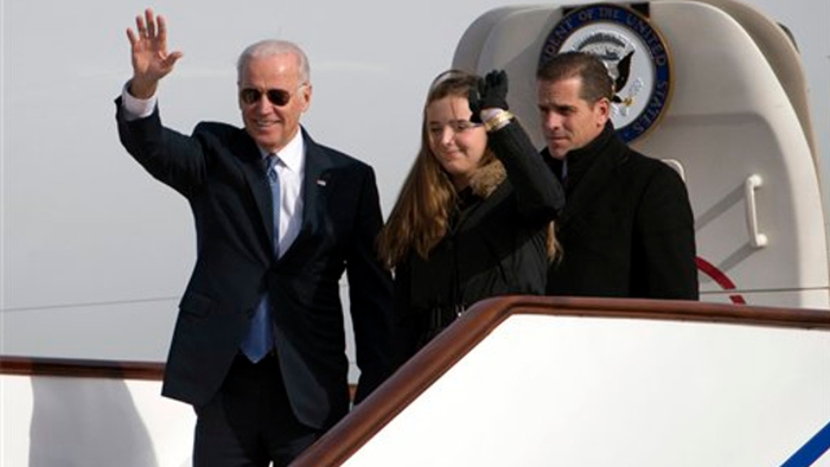 Dec. 4, 2013: Vice President Joe Biden, left, waves as he walks out of Air Force Two with his granddaughter Finnegan Biden and son Hunter Biden at the airport in Beijing, China.