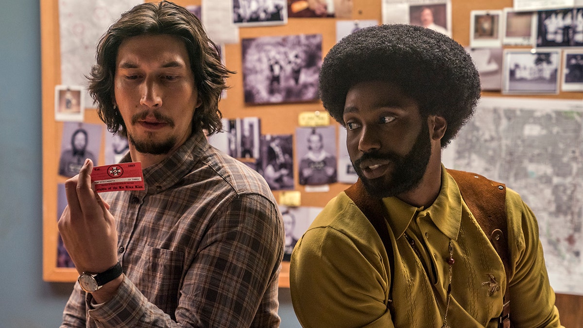 This image released by Focus Features shows Adam Driver, left, and  John David Washington in a scene from 