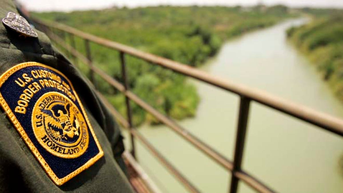 A Border Patrol agent looks over the Rio Grande