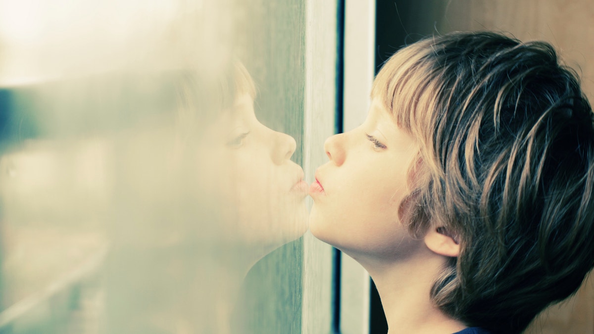 boy looking through window