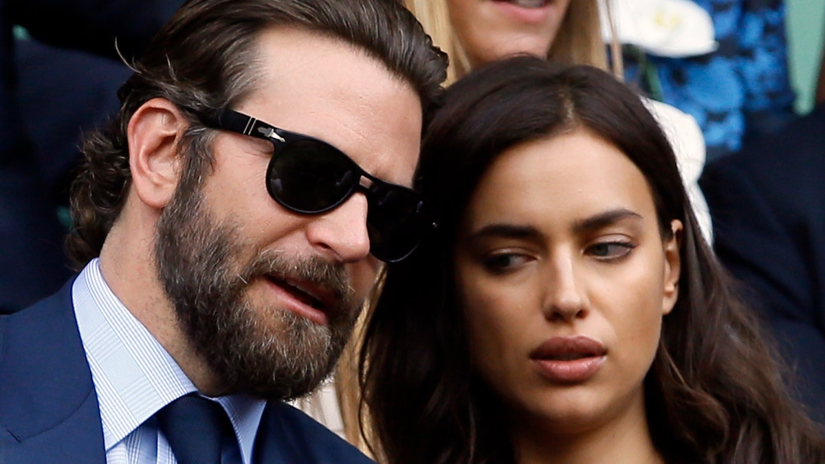 Actor Bradley Cooper, left, speaks with his girlfriend model Irina Shayk on the fourteenth day of the Wimbledon Tennis Championships in London, Sunday, July 10, 2016. (AP Photo/Kirsty Wigglesworth)