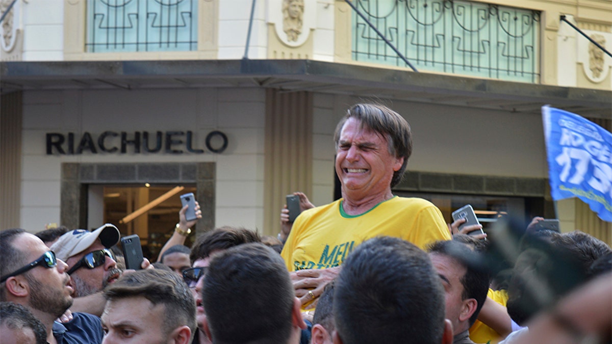 Presidential candidate Jair Bolsonaro grimaces right after being stabbed in the stomach during a campaign rally in Juiz de Fora, Brazil, Thursday, Sept. 6, 2018. Bolsonaro, a leading presidential candidate in Brazil, was stabbed during the campaign event, though officials and his son said the injury is not life-threatening. (AP Photo/Raysa Leite)