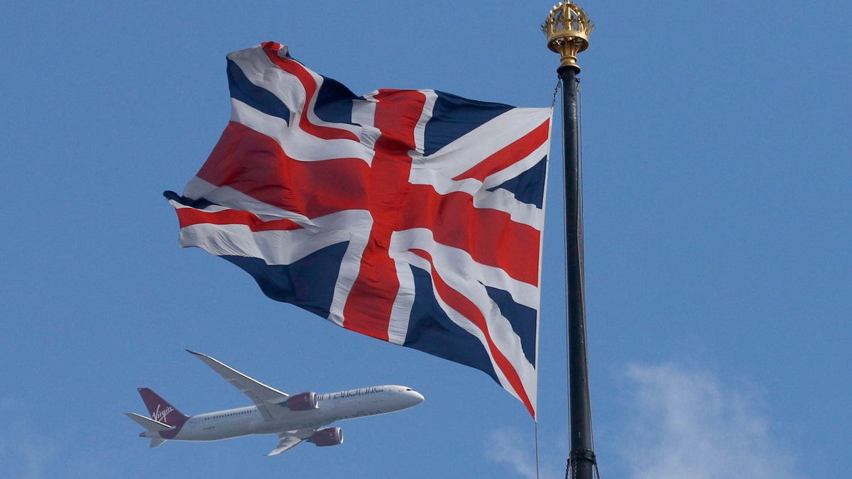 A Virgin Atlantic passenger jet flies past the Union Flag above the Houses of Parliament in Westminster, in central London, Britain June 24, 2016. REUTERS/Phil Noble - RTX2I1AJ