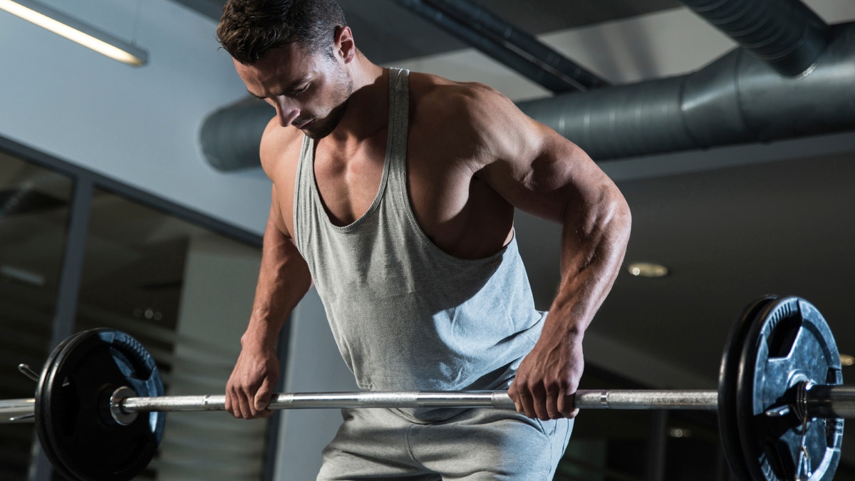 buff man lifting weights istock