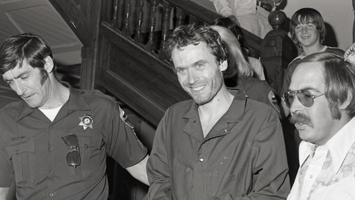 In this 1977 photo serial killer Ted Bundy, center, is escorted out of court in Pitkin County, Colo. The Glenwood Springs Post-Independent discovered the 40-year-old photo of Bundy, along with others, that had been locked in an old safe in the newsroom, which a local locksmith volunteered to open. The photos show Bundy in custody in 1977, the year he escaped from local law enforcement twice while awaiting a murder trial. (Glenwood Springs Post Independent via AP)