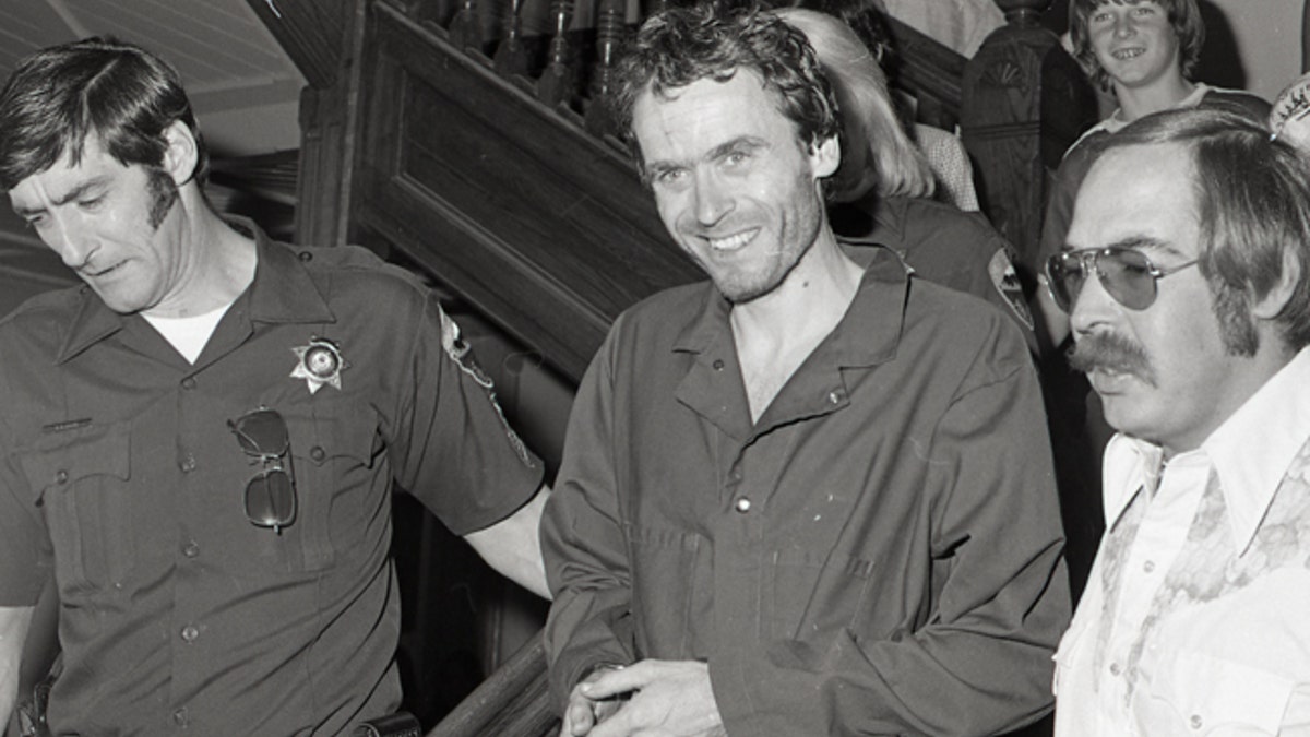 In this 1977 photo serial killer Ted Bundy, center, is escorted out of court in Pitkin County, Colo. The Glenwood Springs Post-Independent discovered the 40-year-old photo of Bundy, along with others, that had been locked in an old safe in the newsroom, which a local locksmith volunteered to open. The photos show Bundy in custody in 1977, the year he escaped from local law enforcement twice while awaiting a murder trial. (Glenwood Springs Post Independent via AP)