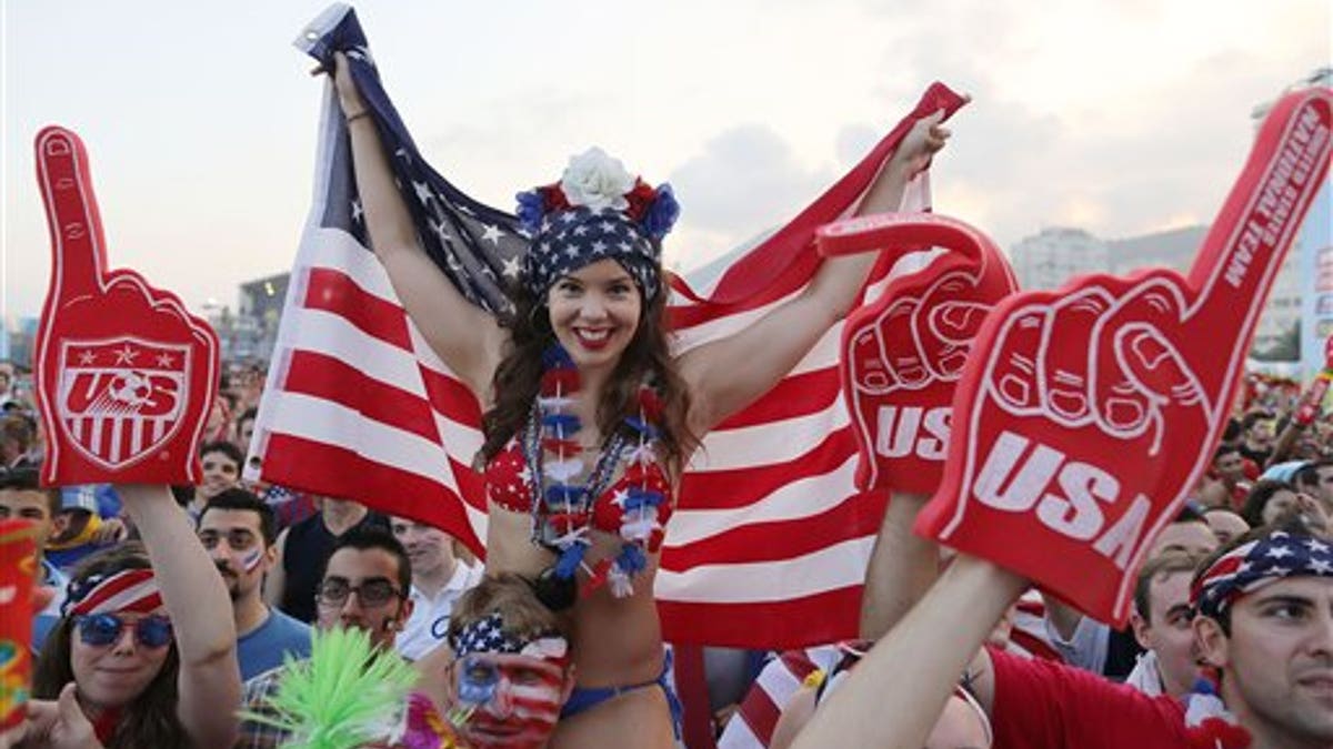 U.S. soccer fan holding a representation of the U.S. flag at FIFA Fan Fest on Copacabana beach