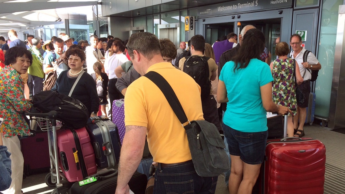Passengers stand with their luggage outside Terminal 5 at London's Heathrow airport after flights were canceled due to the airport suffering an IT systems failure, Saturday, May 27, 2017. British Airways canceled all flights from London's Heathrow and Gatwick airports on Saturday as a global IT failure upended the travel plans of tens of thousands of people on a busy U.K. holiday weekend. (AP Photo /Jo Kearney)