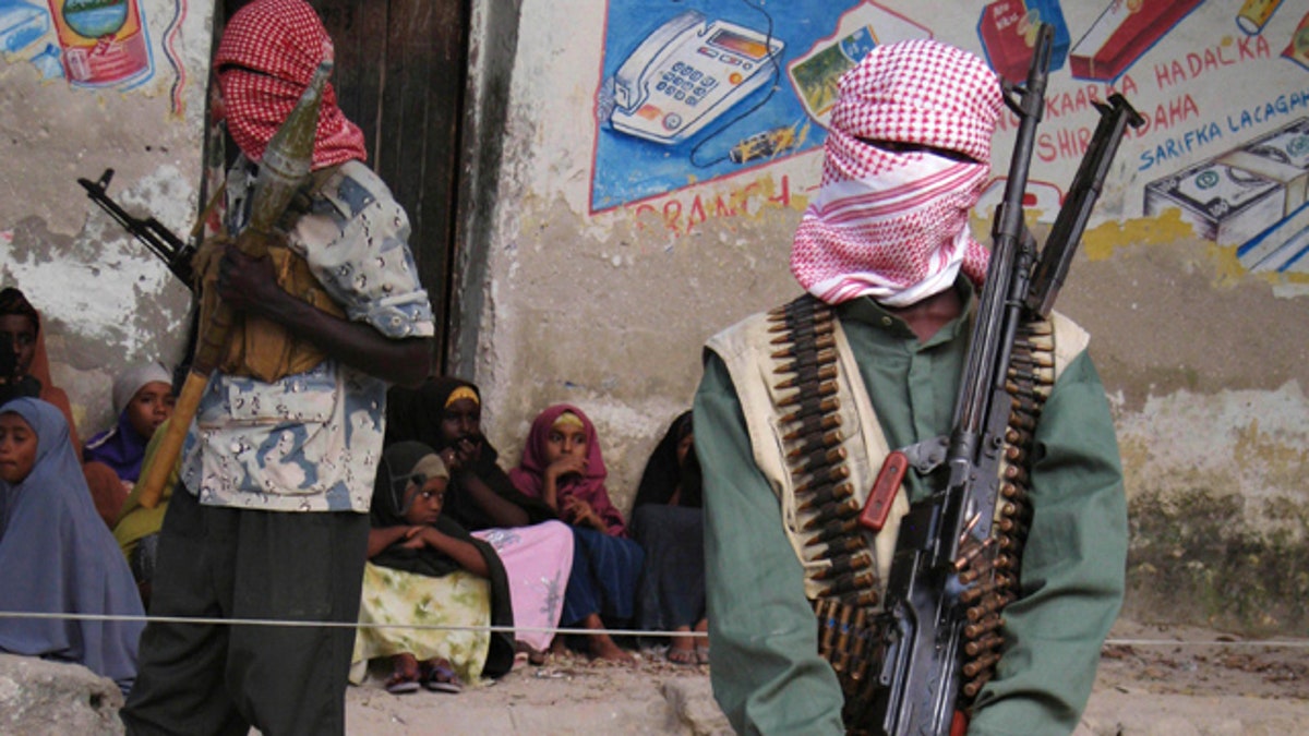 Somali al-Shabab fighters stand stand guard during a public flogging by the hardline Islamic group in Bula Marer town, December 13, 2008. Somalia's President Abulahi Yusuf sacked his prime minister on Sunday, saying he had failed to bring security to the chaotic country. A respected Somali rights group said this week that fighting in the Horn of Africa country had killed more than 16,200 civilians since the start of last year, when allied Somali-Ethiopian forces drove the Islamists out of power. Picture taken December 13, 2008. REUTERS/Ismail Taxta (SOMALIA)