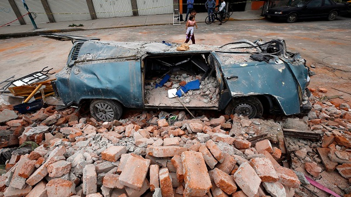 A van sits in a pile of rubble after it was smashed by a wall that collapsed during a massive earthquake, in Mexico City, Friday Sept. 8, 2017. One of the most powerful earthquakes ever to strike Mexico hit off its southern Pacific coast, killing at least 35 people, toppling houses, government offices and businesses. Mexico's capital escaped major damage, but the quake terrified sleeping residents, many of whom still remember the catastrophic 1985 earthquake that killed thousands and devastated large parts of the city. (AP Photo/Marco Ugarte)