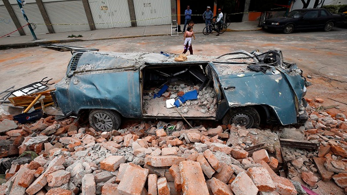 A van sits in a pile of rubble after it was smashed by a wall that collapsed during a massive earthquake, in Mexico City, Friday Sept. 8, 2017. One of the most powerful earthquakes ever to strike Mexico hit off its southern Pacific coast, killing at least 35 people, toppling houses, government offices and businesses. Mexico's capital escaped major damage, but the quake terrified sleeping residents, many of whom still remember the catastrophic 1985 earthquake that killed thousands and devastated large parts of the city. (AP Photo/Marco Ugarte)