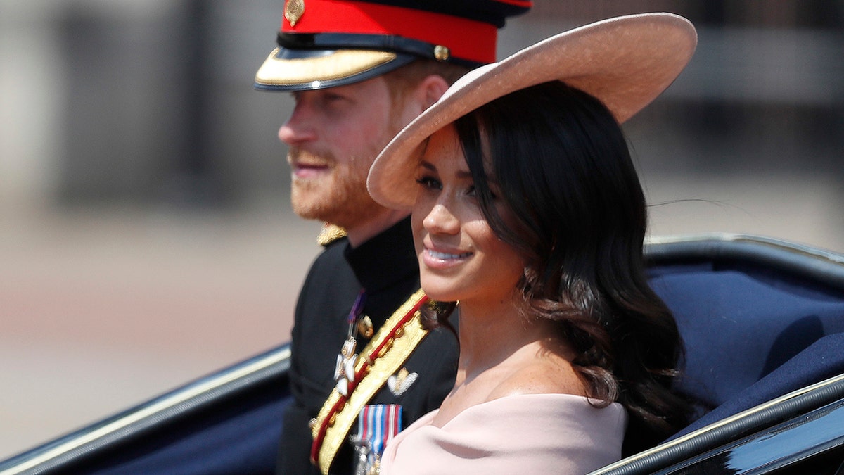 Britains Prince Harry, left, and Meghan, Duchess of Sussex ride in a carriage to attend the annual Trooping the Colour Ceremony in London, Saturday, June 9, 2018.