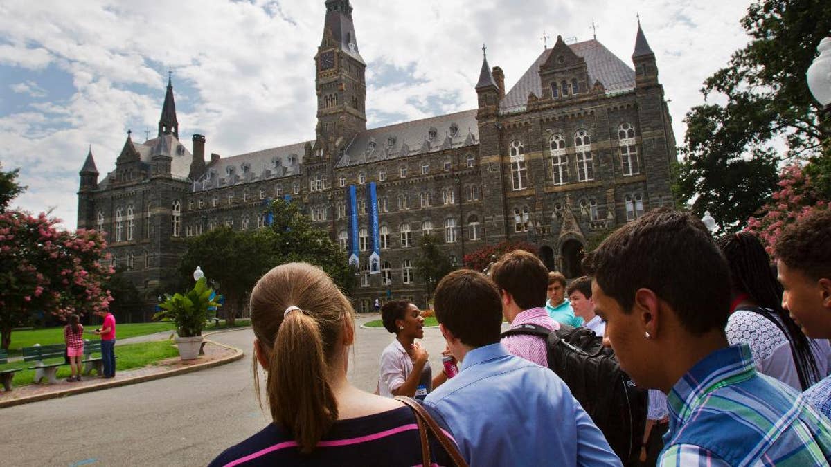 FILE - In this July 10, 2013, file photo, prospective students tour Georgetown University's campus in Washington. Georgetown University will give preference in admissions to the descendants of slaves owned by the Maryland Jesuits as part of its effort to atone for profiting from the sale of enslaved people, the president of the prominent Jesuit university in Washington announced Thursday, Sept. 1, 2016. (AP Photo/Jacquelyn Martin, File)