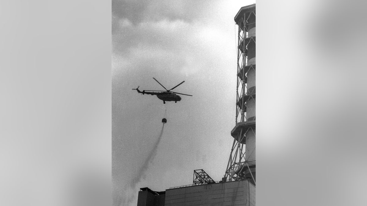 A helicopter dropping concrete onto the fourth reactor of the Chernobyl nuclear power after its explosion is seen in this 1986 file picture. Ukraine marks the 20th anniversary of the Chernobyl nuclear accident, the world's worst civil nuclear disaster, on April 26 this year. The concrete was used for the building of a sarcophagus around the shattered reactor, designed to contain emanating radiation. BLACK AND WHITE ONLY  REUTERS/Vladimir Repik/Files - GM1DSKZQKXAA