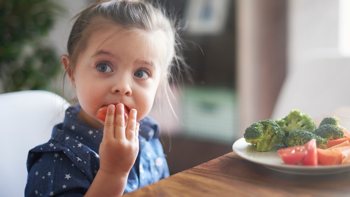 child eating veggies istock